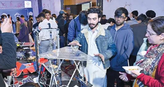 Visitors gathered around a robotics exhibit